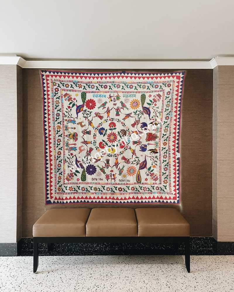 Embroidered wall hanging featuring colorful needlework. Vibrant hand embroidery has elephants and peacocks by the Kutch Rabari community